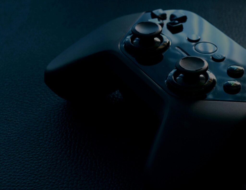 A detailed macro shot of a black game controller with reflections, emphasizing technology and gaming.